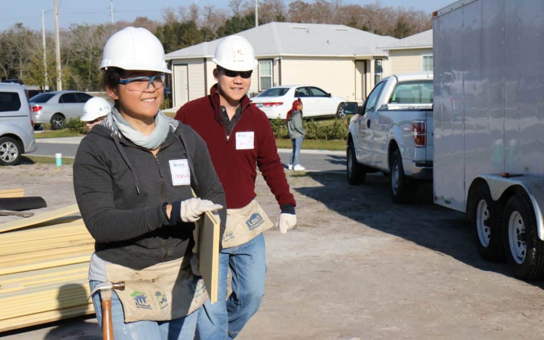 Two Habitat volunteers pose at a construction site.