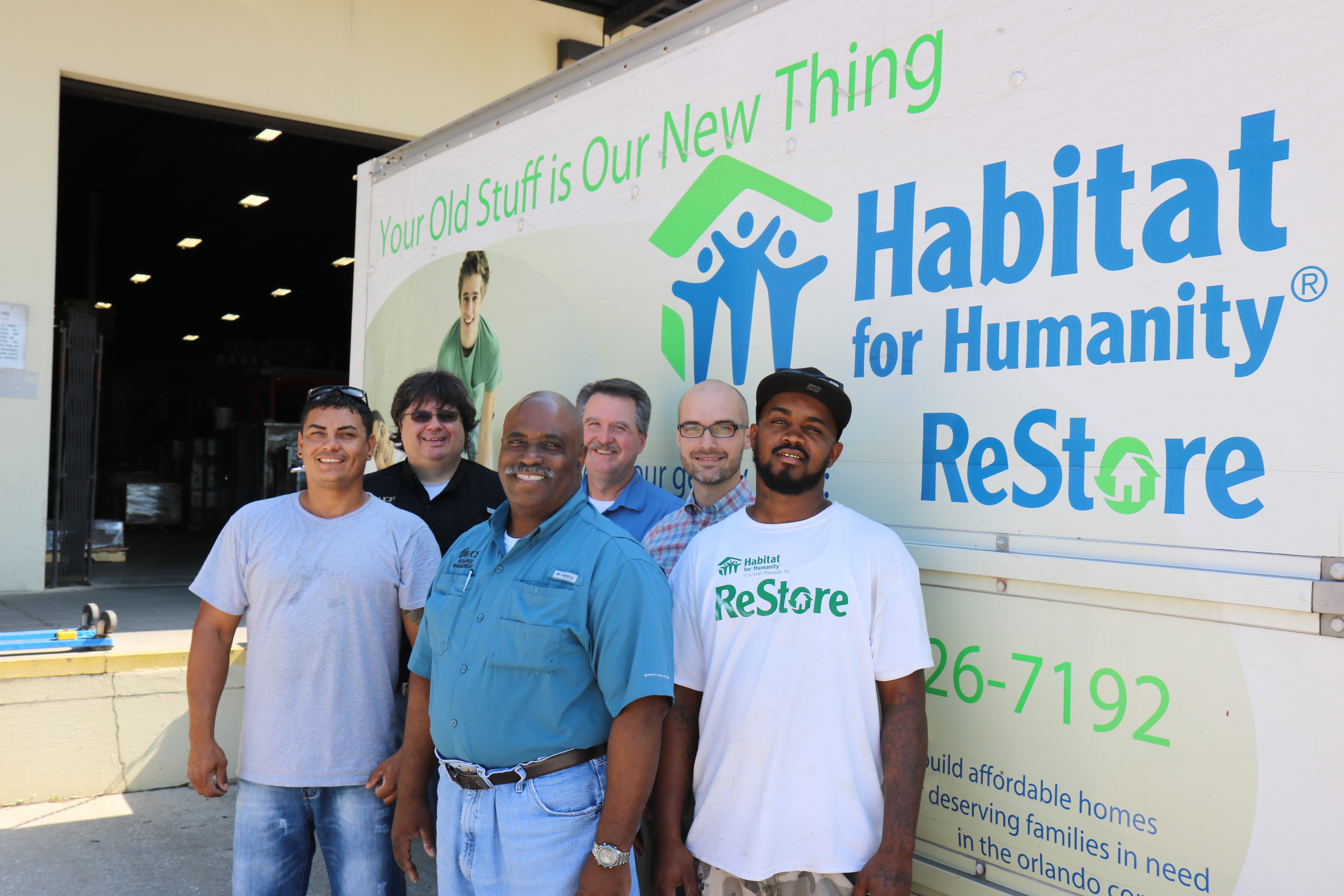 Habitat for Humanity ReStore employees pose in front of a ReStore truck. 