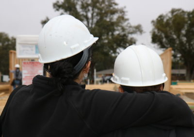Two women embracing looking at walls being raised
