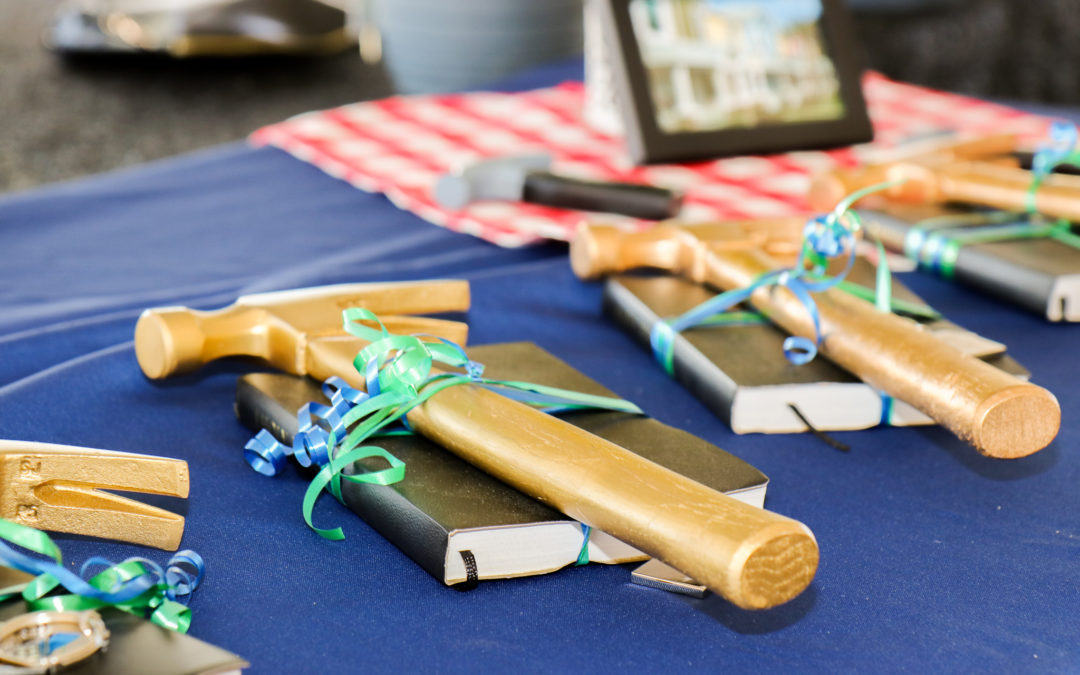 Close-up of golden hammers on top of black Bibles on blue tablecloth