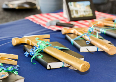 Close-up of golden hammers on top of black Bibles on blue tablecloth