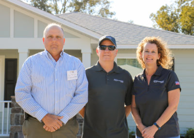 Two men and women standing in front of completed house