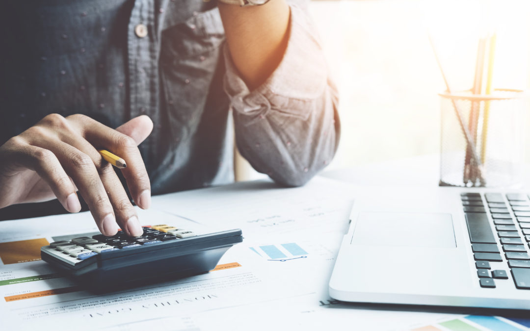 Close up a man working about financial with calculator at his office to calculate expenses