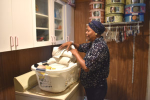 Charlotte folds laundry in her new laundry room. 