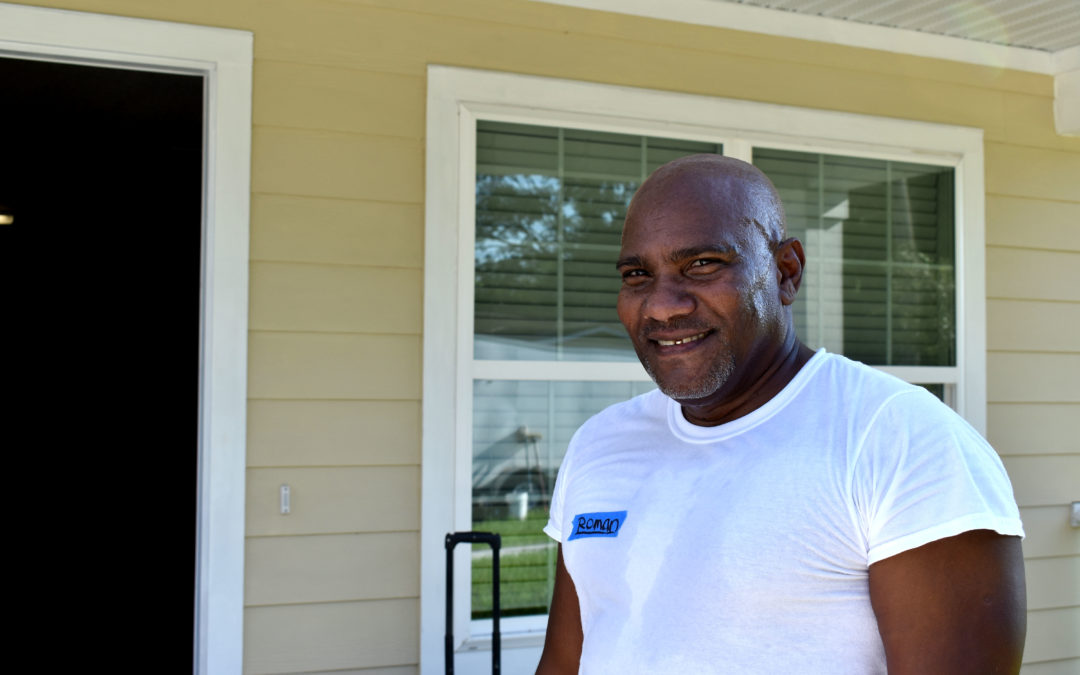 Crew leader Roman in front of house