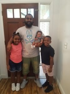 Future homeowner Michael poses with his three children.