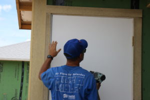 José, jefe de equipo, trabaja en una obra de Hábitat Orlando y Osceola instalando una puerta.