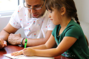 Future homeowner Eliezer drawing with daughter Yosmeli