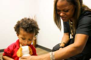 Juliet and her son playing with a plush dog