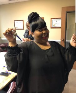 A woman celebrates her home's closing with her new keys in hand