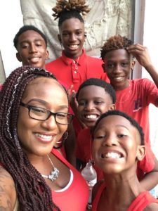 A woman and her five sons, all dressed in red, pose for a photo