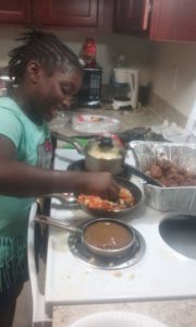 A child cooks vegetables on the stove.