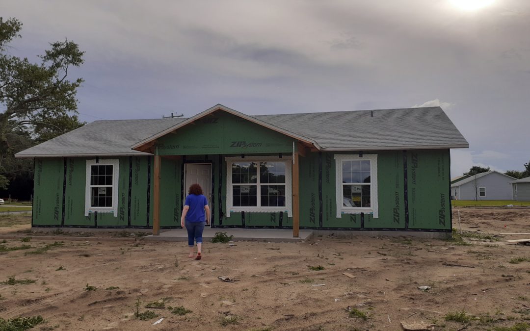 woman walks towards her in-progress house