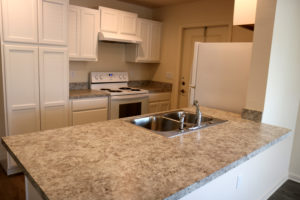 A view of a kitchen with white cabinetry.