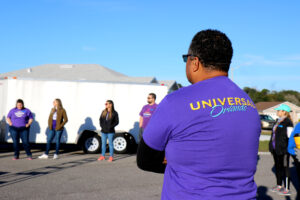 A man in a Universal Orlando shirt stands in a circle awaiting instruction.