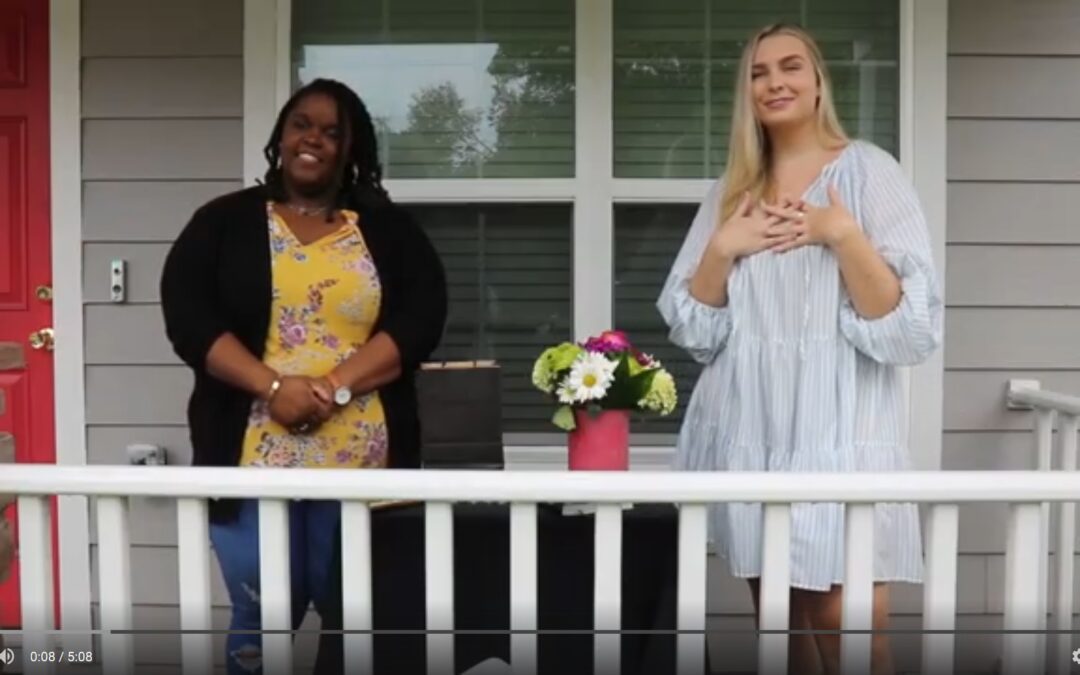 Duas mulheres estão na varanda da frente de uma casa.