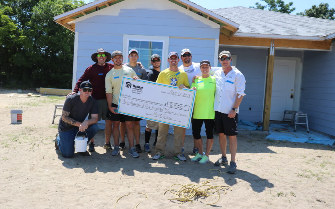 Voluntarios de PaverScape Inc. posan para una foto en un sitio de construcción de Habitat Orlando &amp; Osceola.