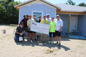 Voluntarios de PaverScape Inc. posan para una foto en un sitio de construcción de Habitat Orlando &amp; Osceola.