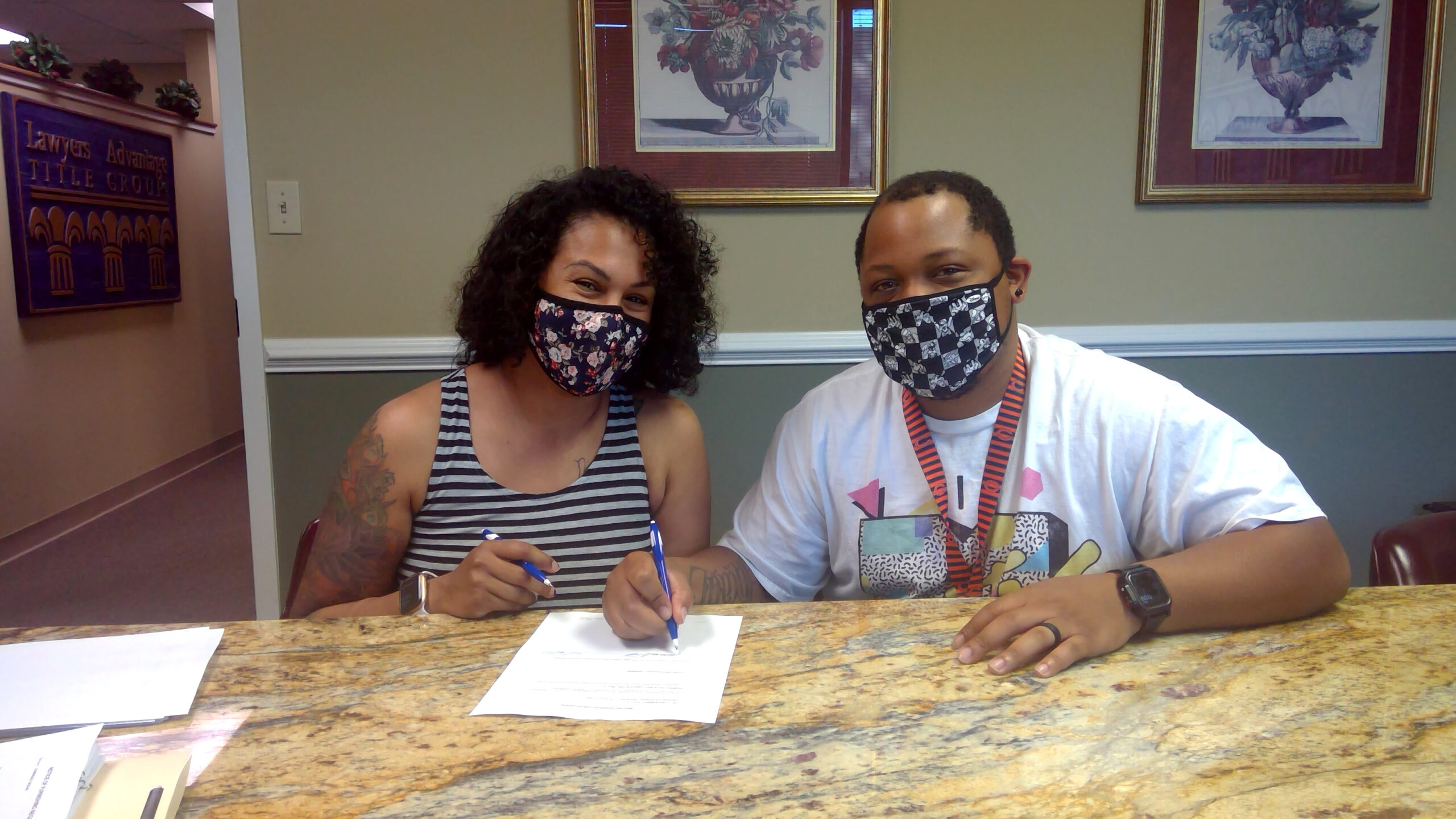 A woman and a man sign a document.