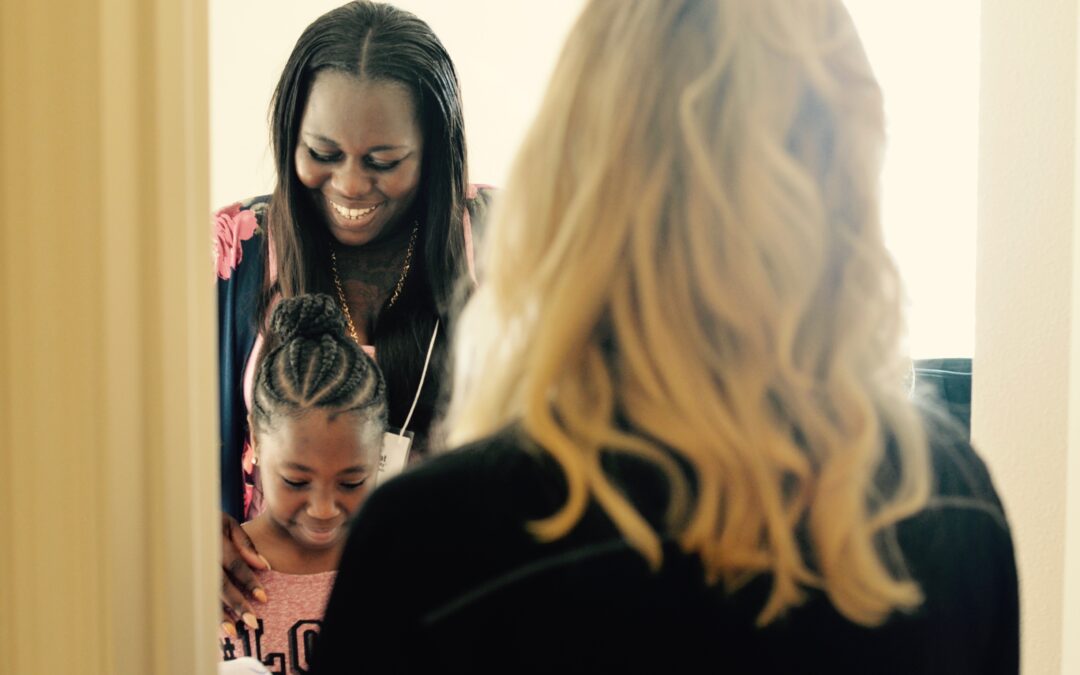 A homeowner and her daughter enter their new home as another woman watches.