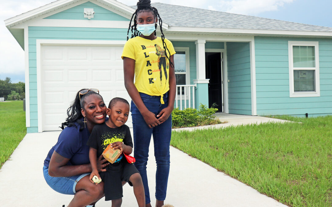 Donya poses in front of her home with two of her three children