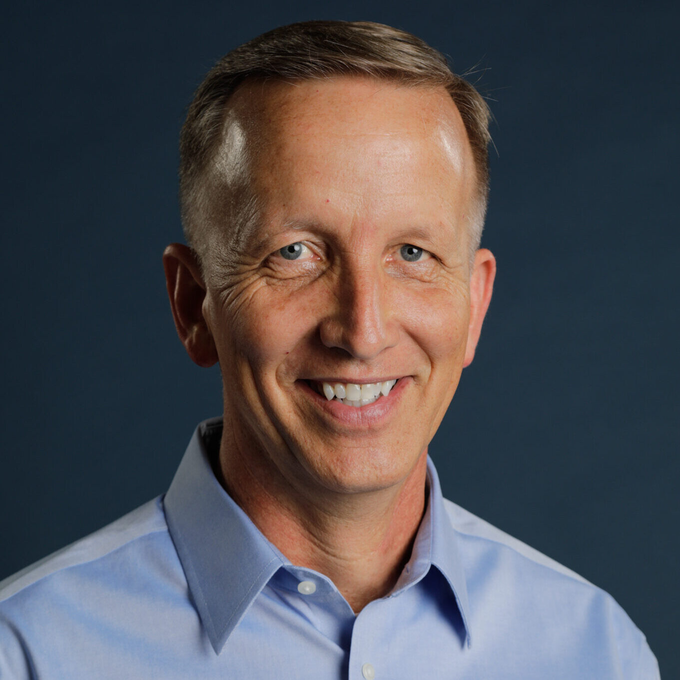 Business man smiling at camera in front of white background