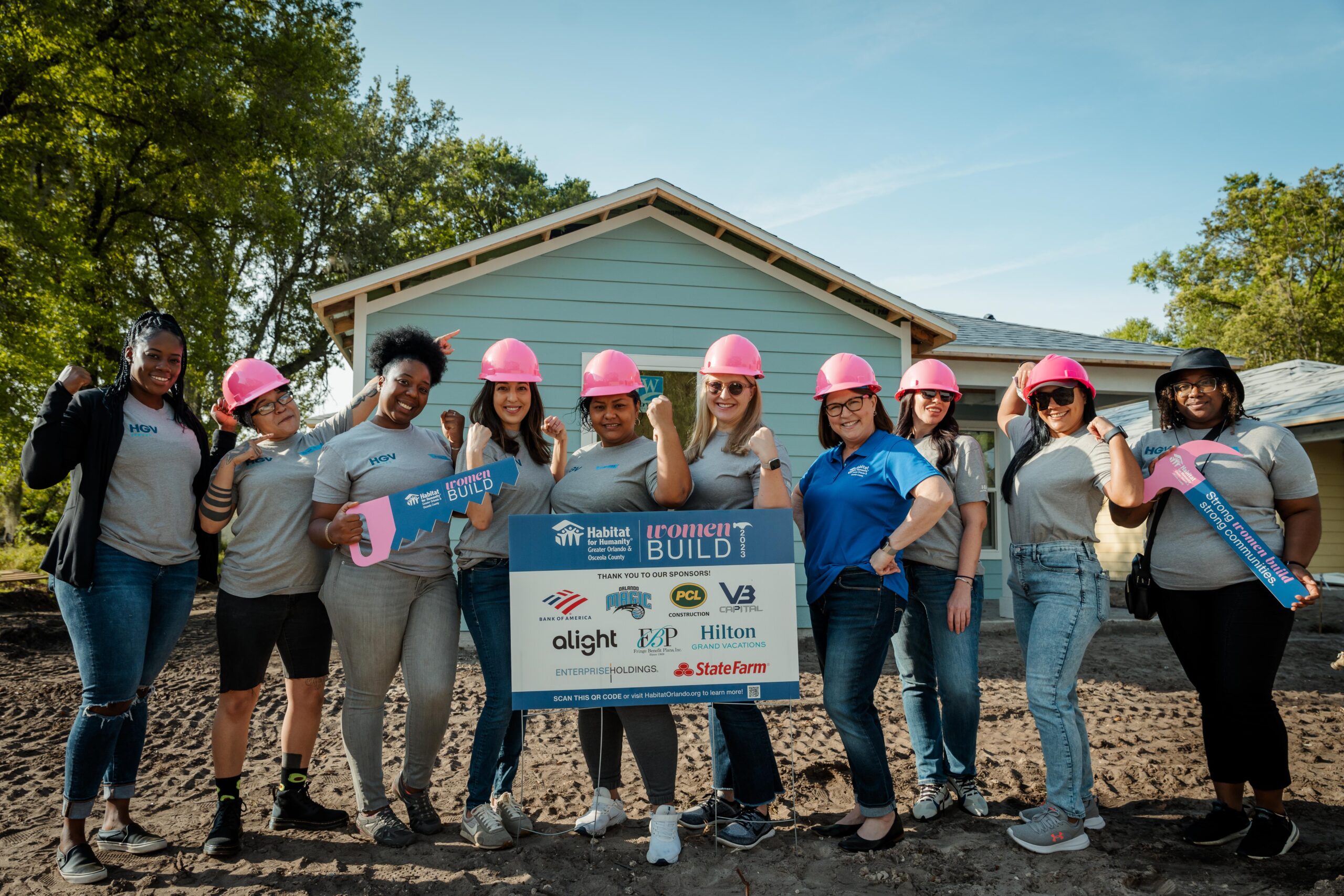Women Build 2023 - HGV_V3-40 Six people stand in front of a house holding a large check.